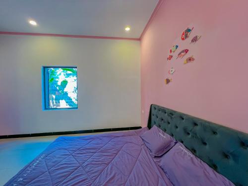 a bedroom with a purple bed and a window at Chon's Dock Homestay & Apartment For Lease in Phan Thiet