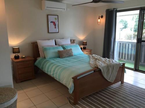 1 dormitorio con cama con sábanas azules y ventana en Goody's Guest House, en Toogoom