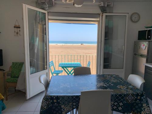 une salle à manger avec une table et une vue sur la plage dans l'établissement Les Corsaires direct plage près du port, à Saint Pierre La Mer