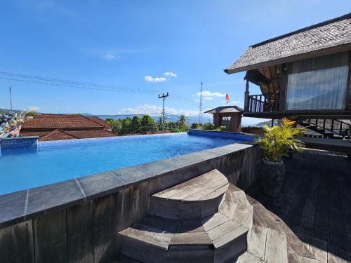 a swimming pool in front of a house at I Guci Home in Munduk