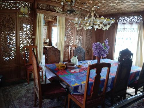 ein Esszimmer mit einem Tisch mit Blumen darauf in der Unterkunft THE Bombay Heritage Group of House boat in Srinagar
