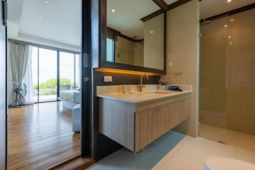 y baño con lavabo y espejo. en Beach Front 4 Bedroom Pool Villa VR, en Hua Hin