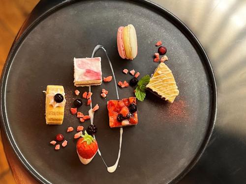 a black plate with different types of food on it at THE KNOT SAPPORO in Sapporo