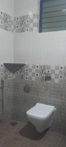 a bathroom with a white toilet and a shower at Eve Resort in Patnem