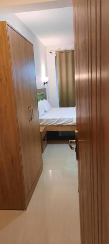a small room with a bed and a wooden door at Eve Resort in Patnem