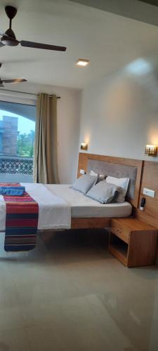 a bedroom with a large bed and a window at Eve Resort in Patnem