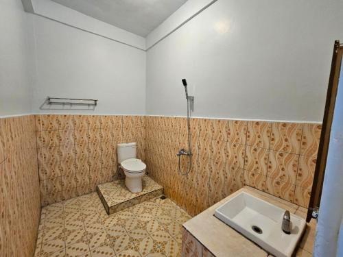 a bathroom with a toilet and a sink at Thyesza Hotel in Ambarita