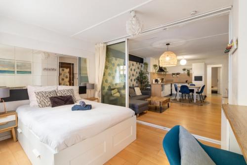 - une chambre avec un lit blanc et un salon dans l'établissement 2 pièces spacieux hyper-centre, à Toulouse