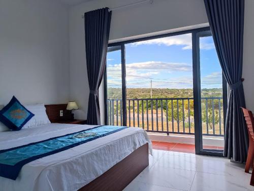 ein Schlafzimmer mit einem Bett und einem großen Fenster in der Unterkunft Đức Lưu Quang Hotel Bình Thuận in Tuy Phong