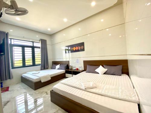 sypialnia z 2 łóżkami i dużym oknem w obiekcie Motel Hòa Hiệp w mieście Binh Chau