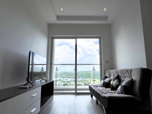 a living room with a couch and a large window at Sihanouk City View Condominium in Sihanoukville