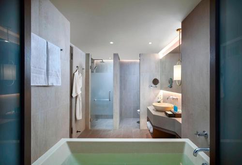 a bathroom with a tub and a shower and a sink at Amari Vogue Krabi in Tab Kaek Beach