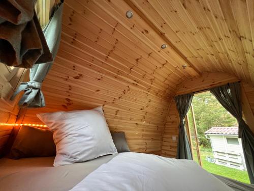 Cama en habitación con techo de madera en Ferienhaus im Wald, en Borkwalde