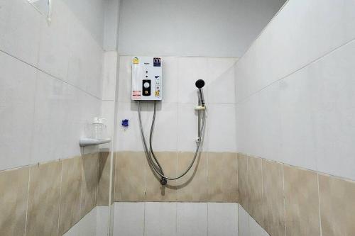 a shower in a bathroom with a hose on the wall at Garden house in Aonang in Krabi town