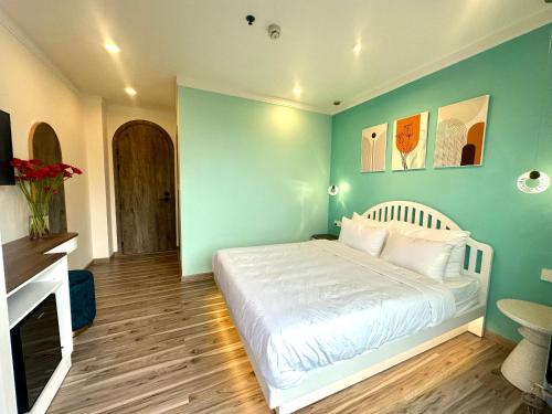 a bedroom with a white bed and a blue wall at Memory Inn - Valley View in Xuan An