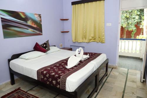 una camera da letto con un letto e asciugamani bianchi di Dona Sa Maria Eco Hotel a Cavelossim