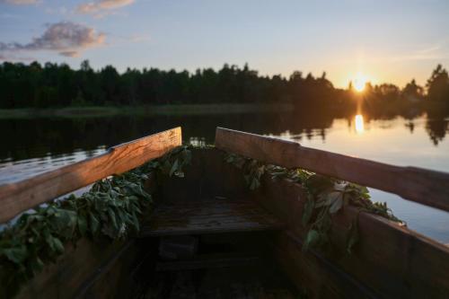 a boat on a lake with the sun in the background at Ambercoast in Jūrmala