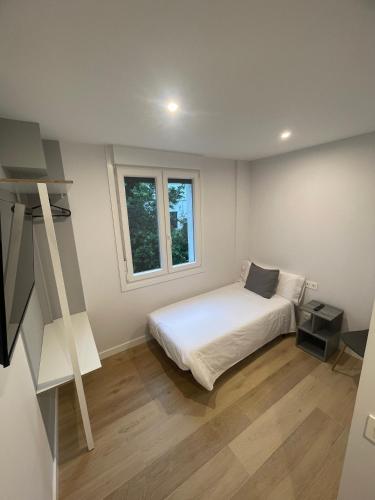 a bedroom with a white bed and a window at Habitaciones Arrisal in Bilbao