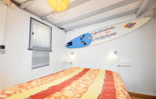 una tabla de surf colgada en una pared junto a una cama en Nice Home In Torreilles With Kitchen, en Torreilles