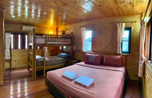 een slaapkamer met een bed en een stapelbed bij Baan Soontree Resort in Chiang Rai