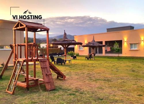 a playground with a swing set and umbrellas at Vi Hosting Cabañas Premium in Salta