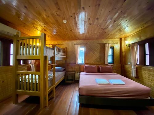 1 dormitorio con 2 literas y escalera en Baan Soontree Resort, en Chiang Rai