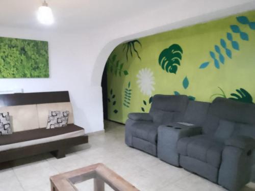 a living room with a couch and a green wall at Casita del Árbol in Mexico City