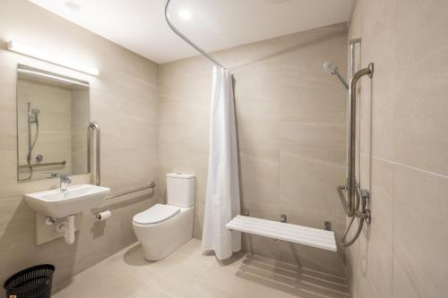 W łazience znajduje się toaleta, umywalka i prysznic. w obiekcie Manha Hotel Auckland Airport w Auckland