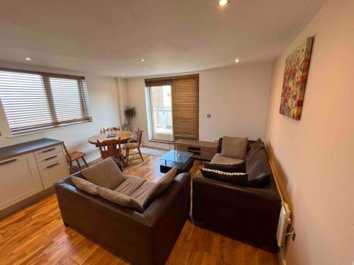 a living room with two couches and a table at Avalon apartment city center of brighton & hove in Brighton & Hove