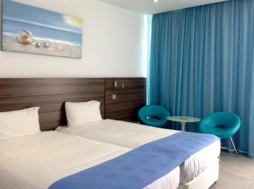Postel nebo postele na pokoji v ubytování Limanaki Beach Hotel & Suites