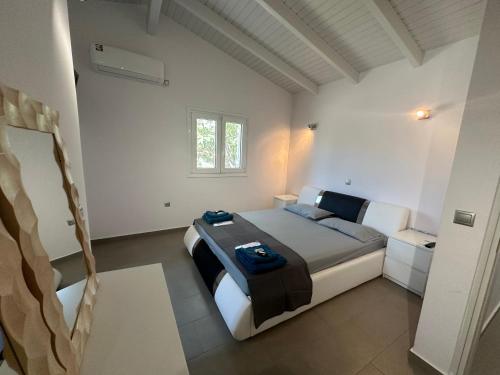 a bedroom with a large bed and a window at Ocean Waves - Alykes Beach in Drosia