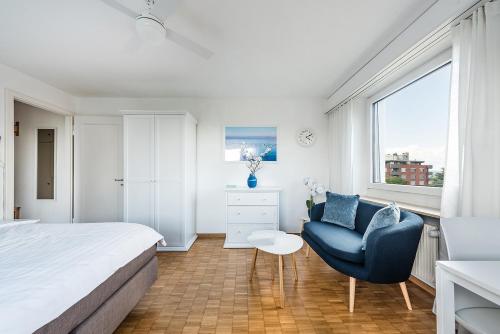 een slaapkamer met een bed, een stoel en een raam bij Cooldis 6 !Gratis Parken, Free Parking! in Kreuzlingen