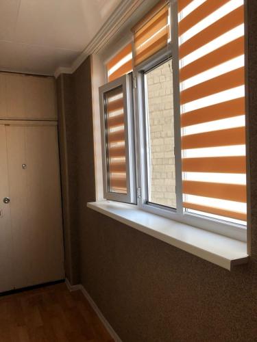een kamer met 2 ramen en een vensterbank bij Квартира в Актау in Aqtau