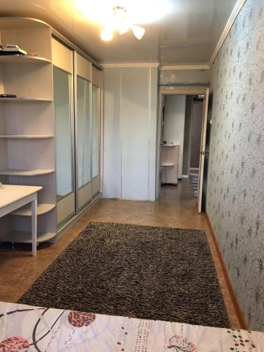 een lege kamer met een tapijt op de vloer bij Квартира в Актау in Aqtau