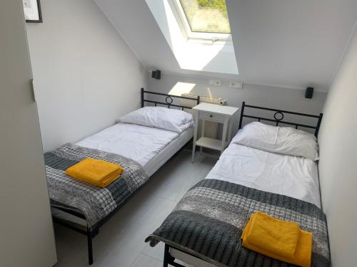 two beds in a small room with a window at AMBER Dębki in Dębki