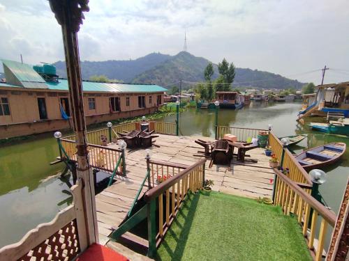 a wooden deck with tables and chairs on the water at THE Bombay Heritage Group of House boat in Srinagar