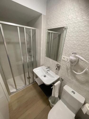 a bathroom with a shower and a toilet and a sink at Habitaciones Arrisal in Bilbao
