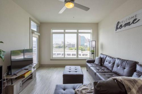 a living room with a couch and a large window at Upscale Apartment on RiverWalk in San Antonio