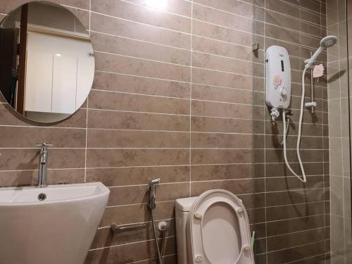 een badkamer met een toilet en een telefoon aan de muur bij Lovely Kozi Square comfort Studio Home 3B in Kuching