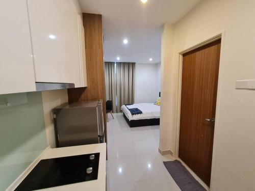 een kamer met een keuken en een slaapkamer met een bed bij Lovely Kozi Square comfort Studio Home 3B in Kuching