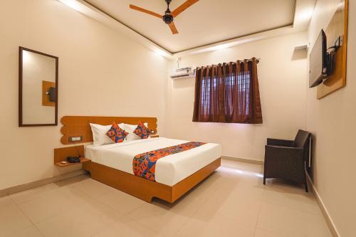 um quarto com uma cama e uma televisão em FabExpress Grand View em Bangalore