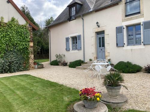 a yard with a house with a chair and a table at Gîte de l’enclos in Menetou-Râtel