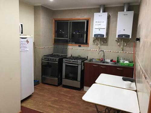 a kitchen with a stove and a refrigerator at Hostal AGUSTÍN II in Cartagena