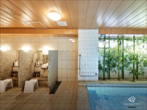 a bathroom with a swimming pool next to a tub at Daiwa Roynet Hotel Nagoya Fushimi in Nagoya