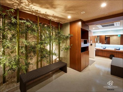 un vestíbulo con un banco y plantas en la pared en Daiwa Roynet Hotel Nagoya Fushimi en Nagoya