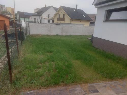 a yard with a fence and green grass at Ubytování Stračenská in Štětí
