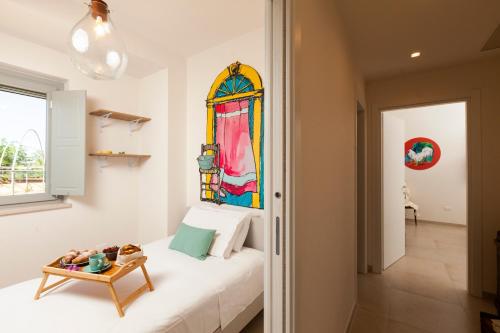 een slaapkamer met een wit bed en een glas-in-loodraam bij Floresia-Your Apulian Experience in Conversano