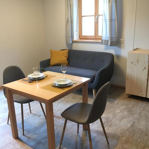 una sala de estar con una mesa y un sofá en Büchlhof - App. Breitenstein, en Lilienfeld