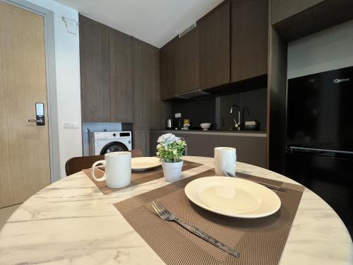 a table with plates and utensils on it in a kitchen at Grand Medini Residence by Luxecocoo CK Legoland in Nusajaya