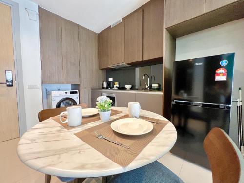 a wooden table in a kitchen with a black refrigerator at Grand Medini Residence by Luxecocoo CK Legoland in Nusajaya